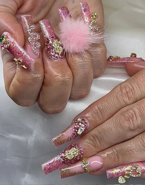 Glitterrosa naglar med stenar, pälsboll och gulddetaljer